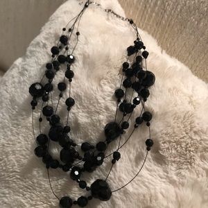 Multi strand, multi size beveled black beads.
